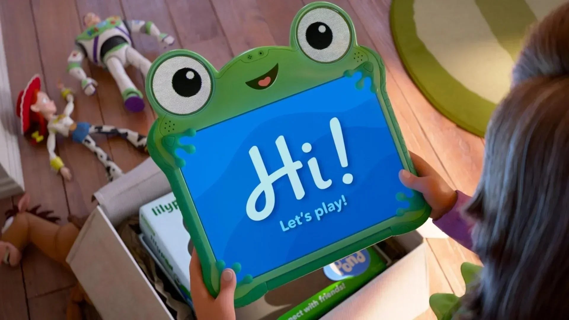 Concept art of the Toy Story 5 tablet showing its green frog-themed design with soft rubber corners and a bright screen displaying animated eyes.