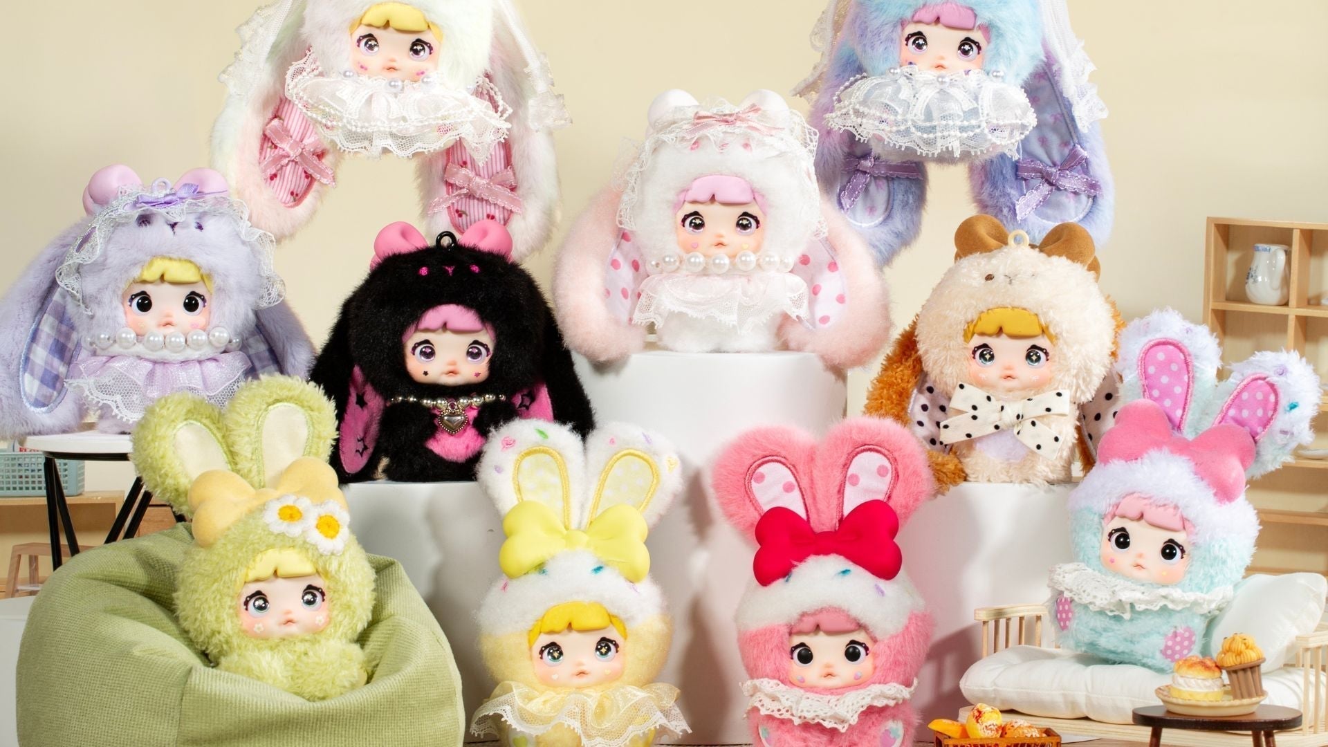 Nommi Baby Sweetheart Bunny plush keychain collection display featuring pastel fuzzy lace bunny dolls with colorful bows in cute indoor studio setting