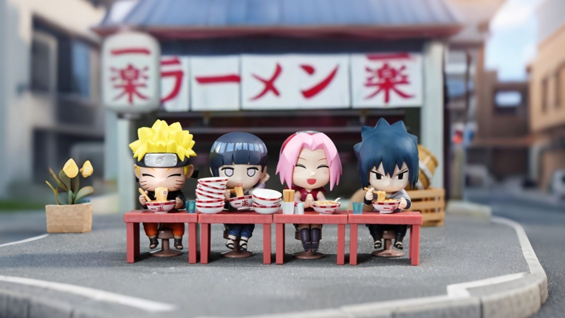 Nendoroid figures of Naruto, Hinata, Sakura and Sasuke eating ramen outside Ichiraku Ramen Shop miniature street scene, cute Naruto anime diorama